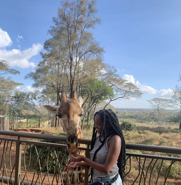 Betty a giraffe at Giraffe center Nairobi with a happy tourist